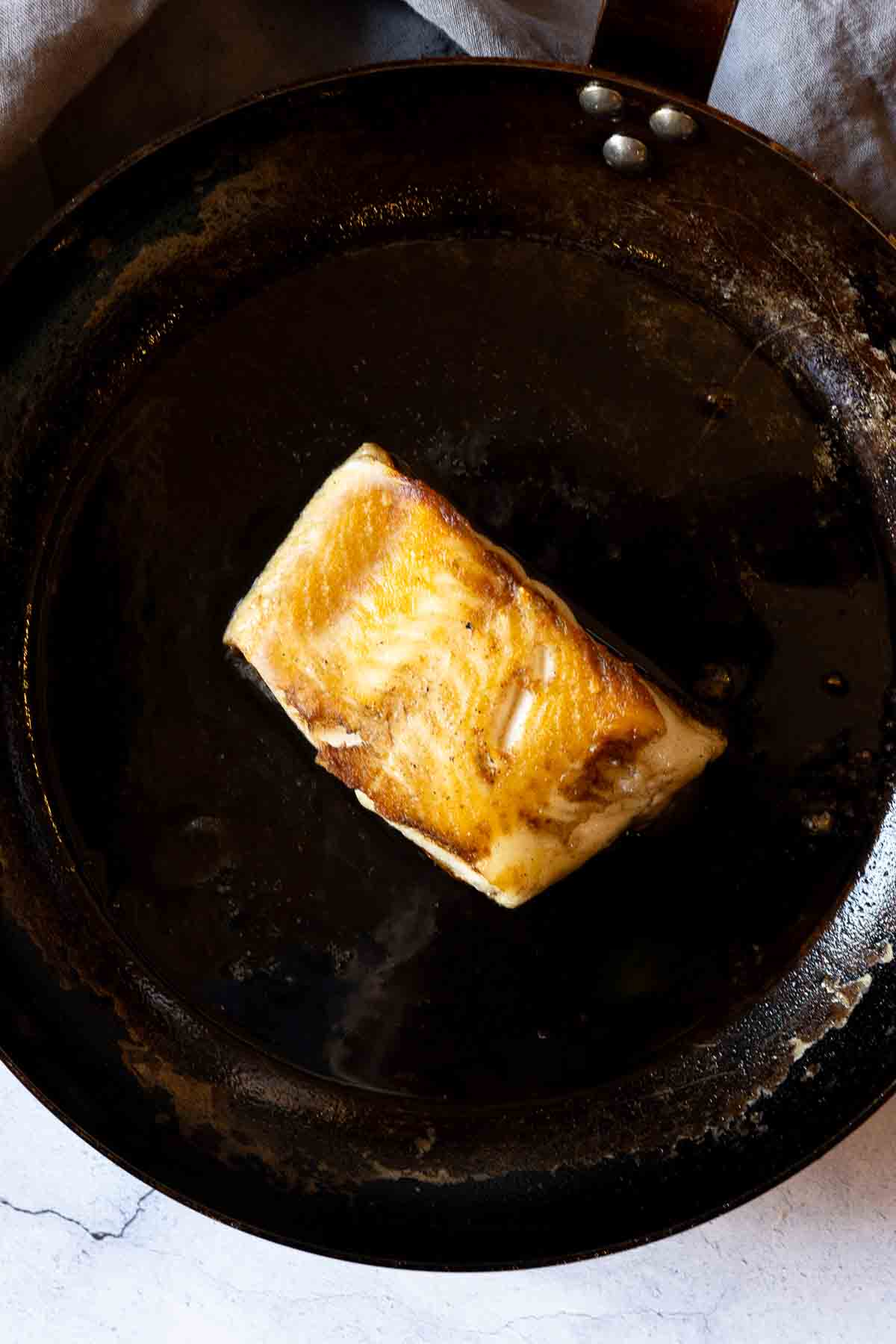 Pan frying sea bass.