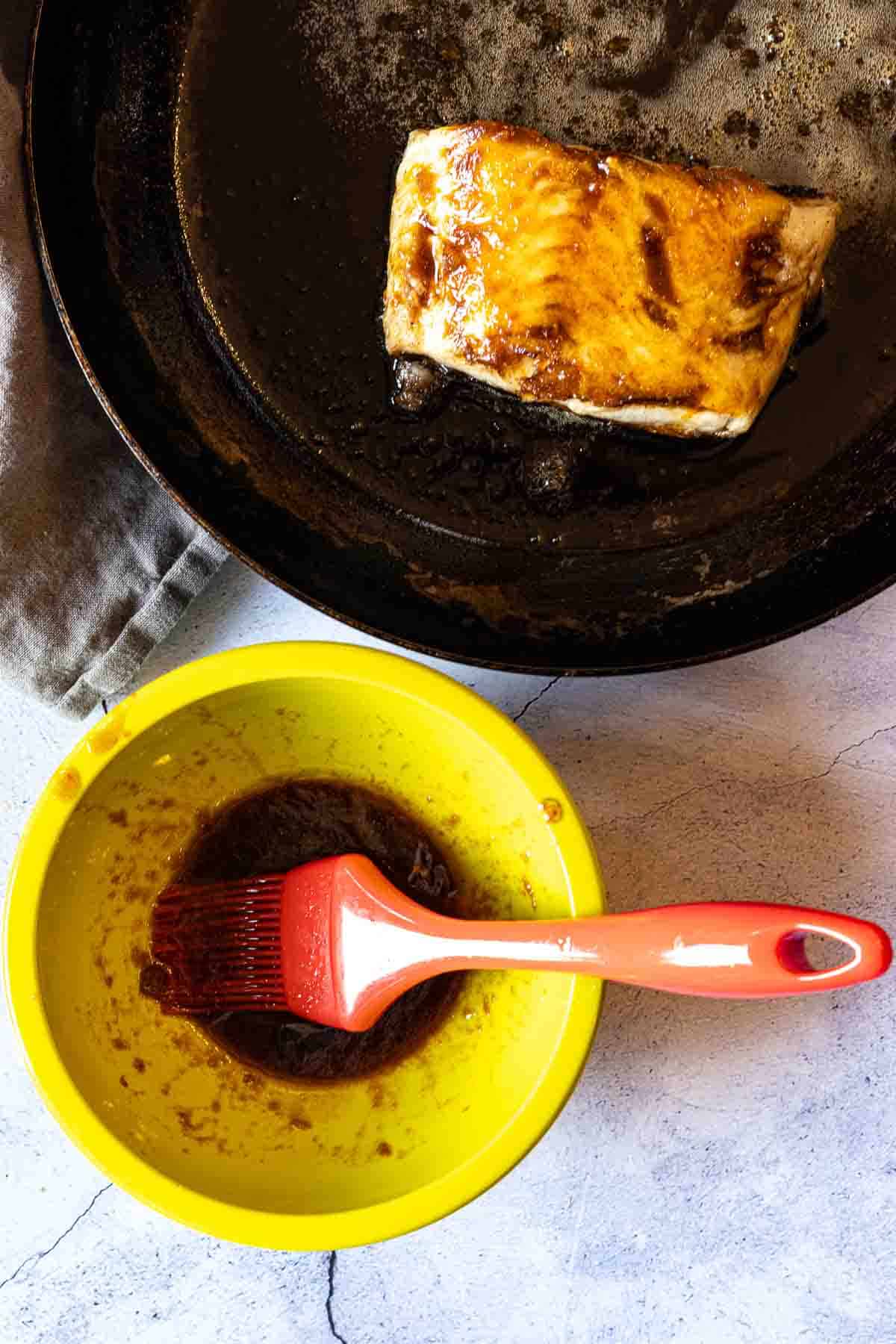 Brushing the sauce on pan fried sea bass.