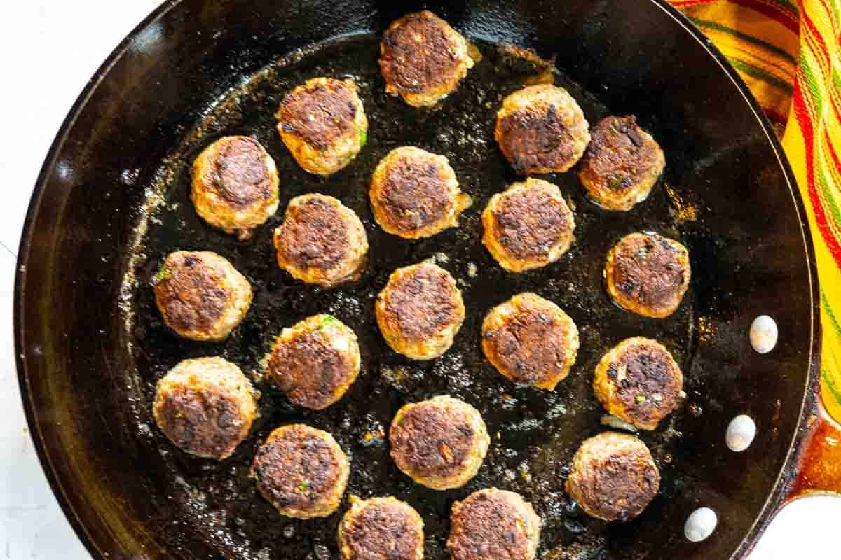 Bison Meatballs fried in a skillet.