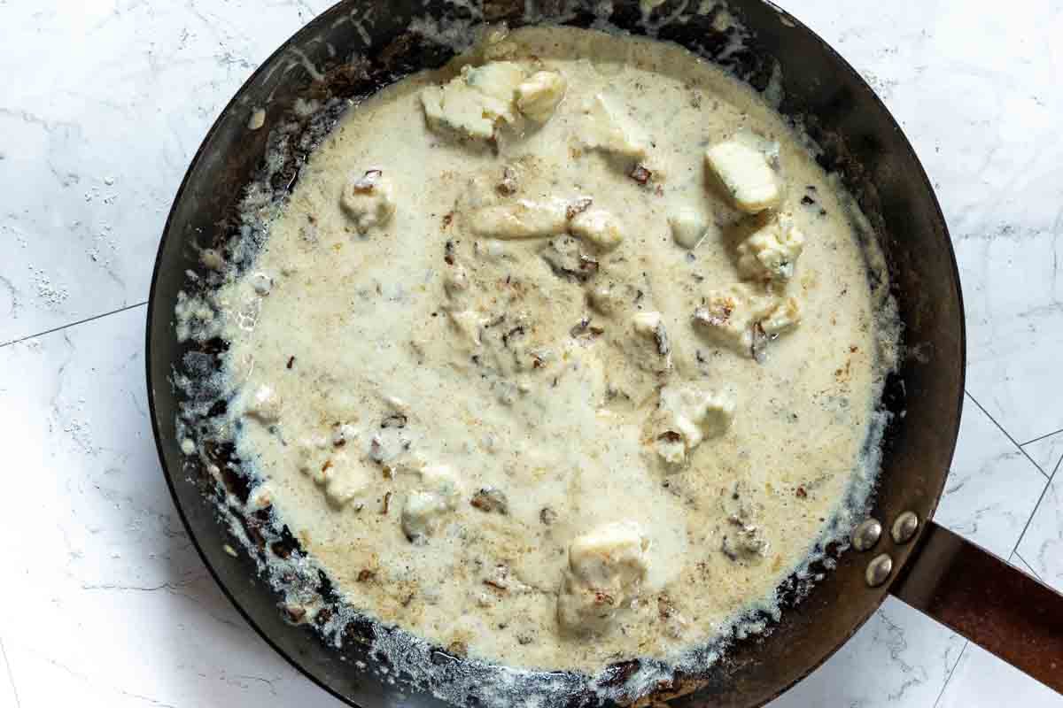 Step 3, adding blue cheese to make blue cheese sauce for a Denver steak.