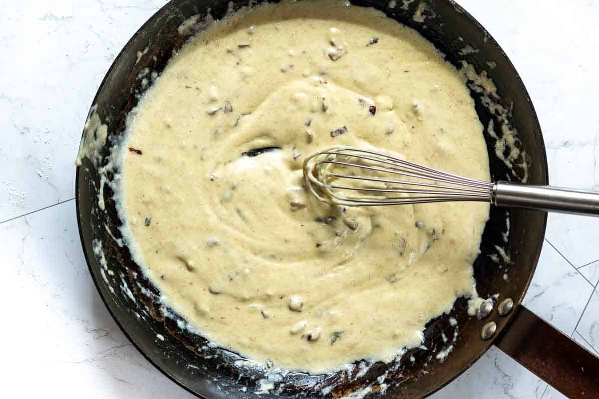 Stirring blue cheese sauce until smooth and creamy. Step 4.
