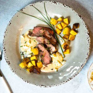 Denver steak with blue cheese sauce served with fried potatoes.
