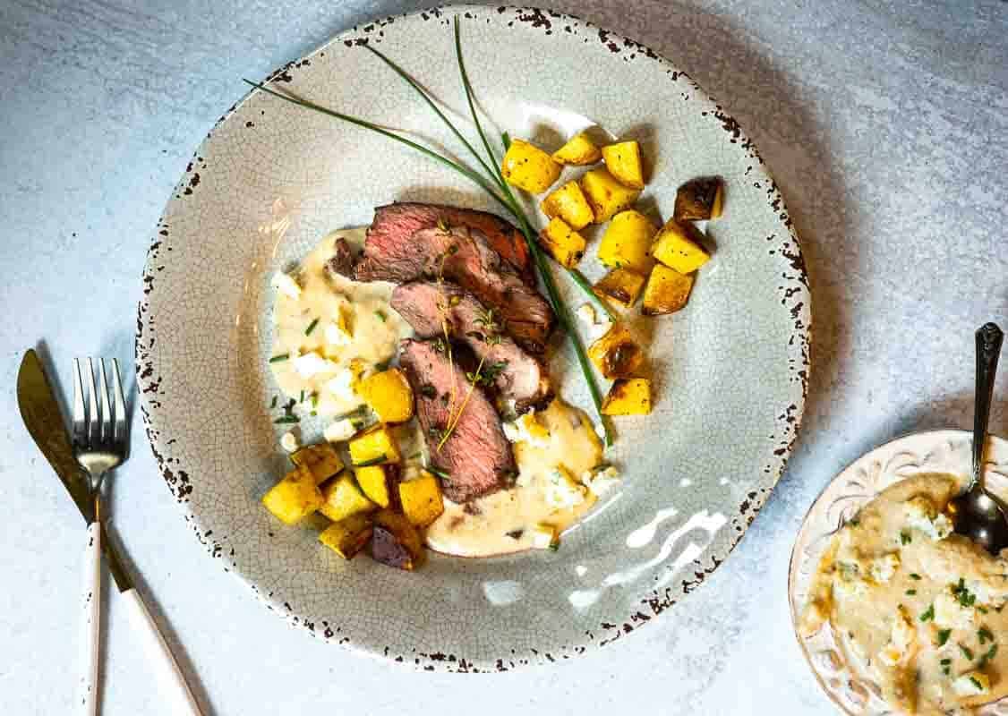 Pan seared Denver steak served with fried potatoes and Blue Cheese Sauce.