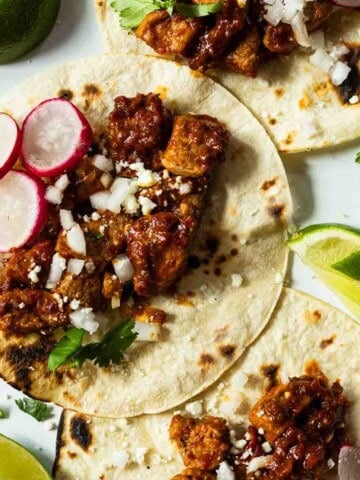 Pork tenderloin tacos with guajillo chile sauce.