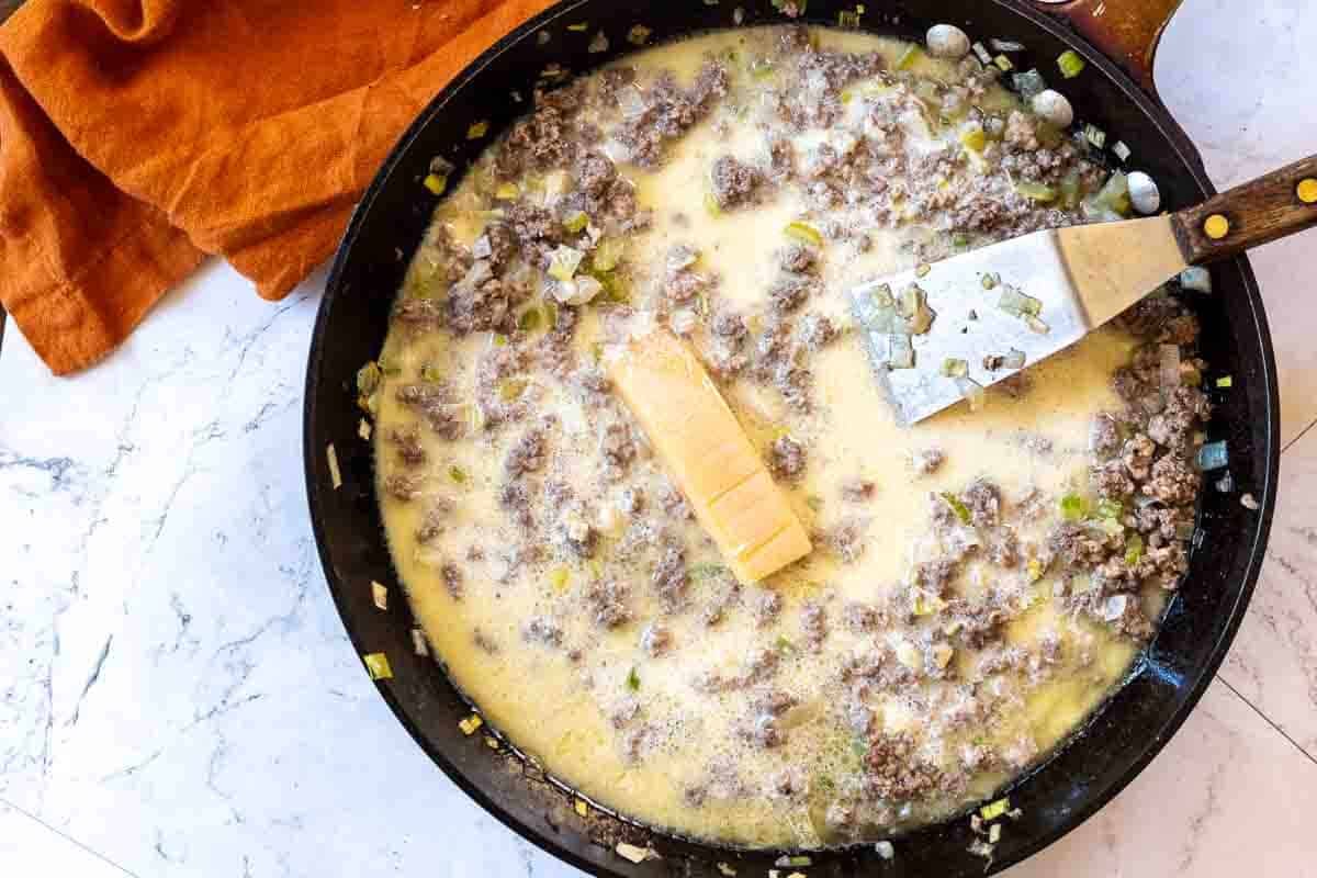 Adding dairy to meat sauce to make white bolognese, step 2.