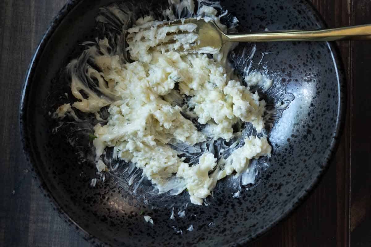 Smashing ingredients with a fork to make blue cheese butter for Merlot steak.