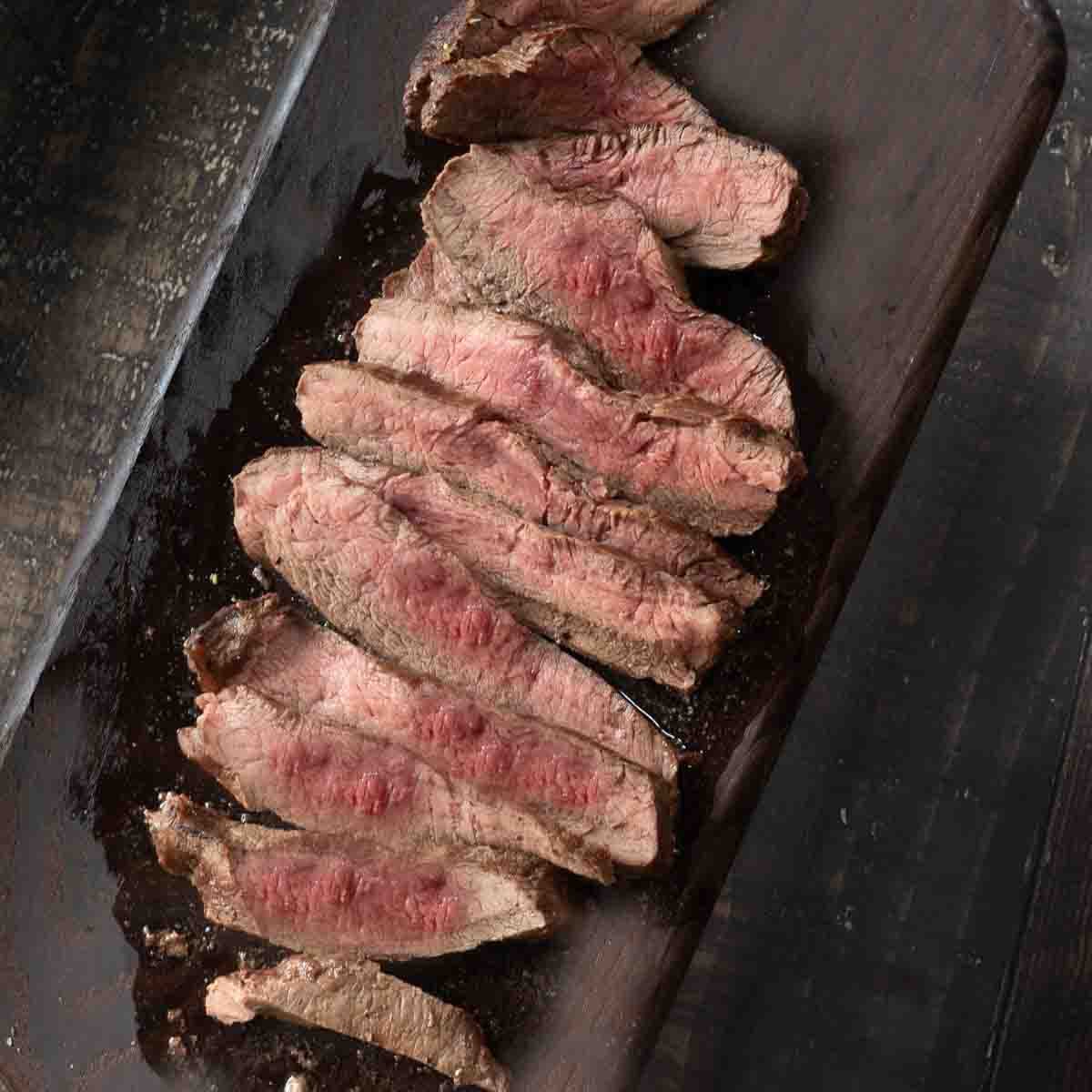 Sliced merlot steak on a cutting board.