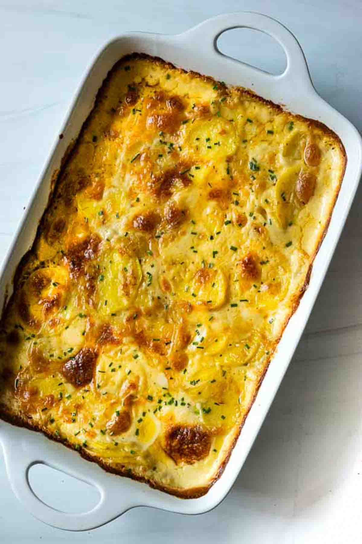 Gluten free scalloped potatoes in a white casserole dish.