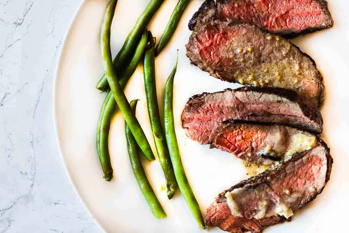 Pan seared baseball top sirloin steak served with green beans.