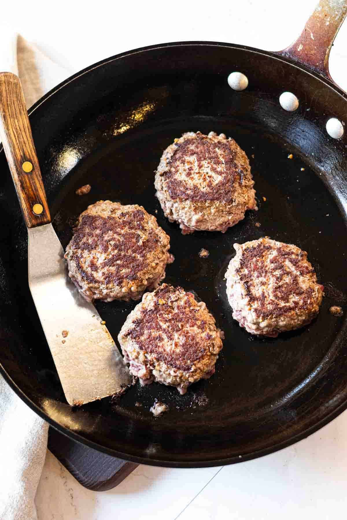 Pan searing burger patties to make Maverick burgers.