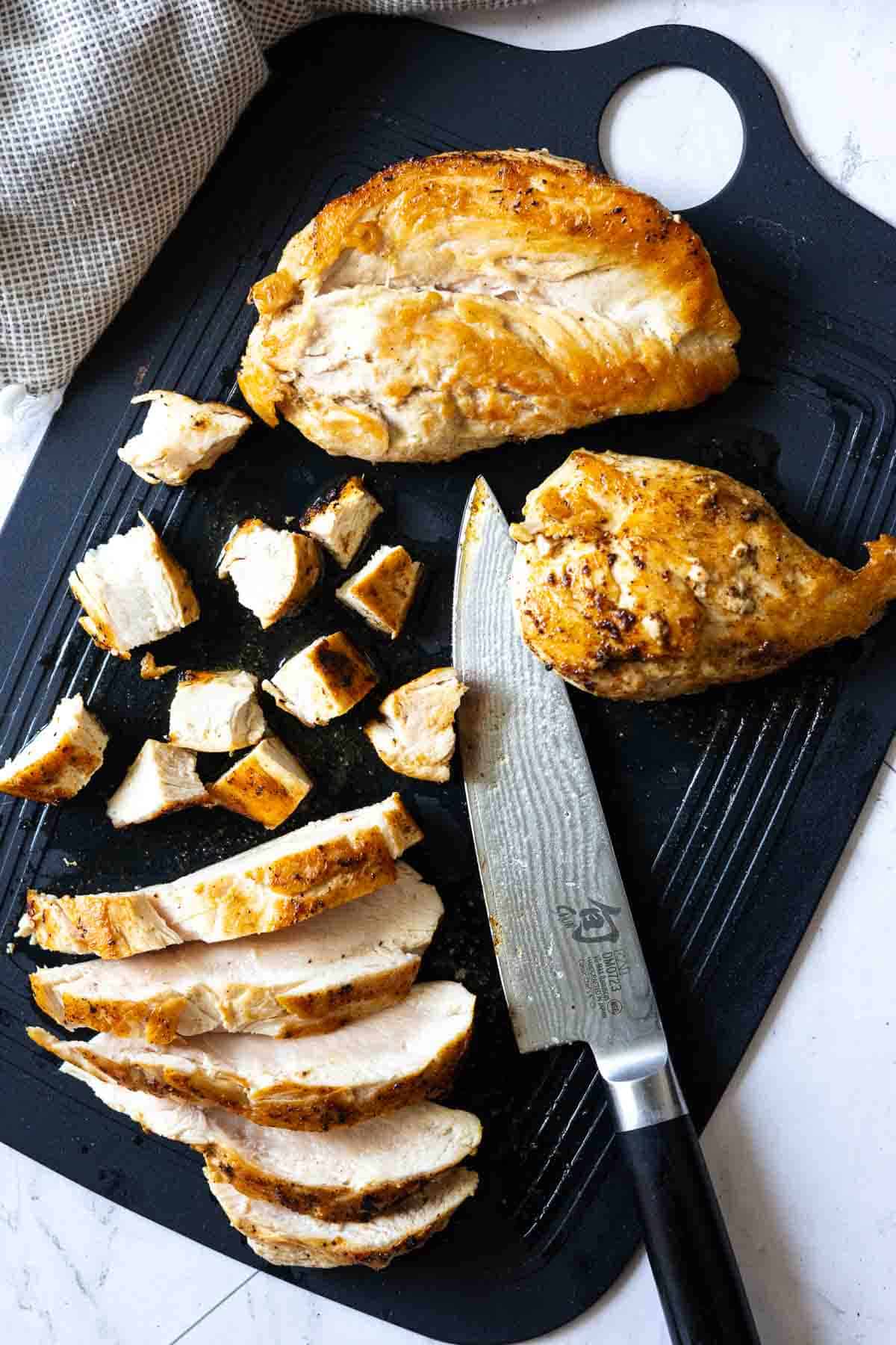 Slicing cooked chicken breasts for chicken cabbage soup.
