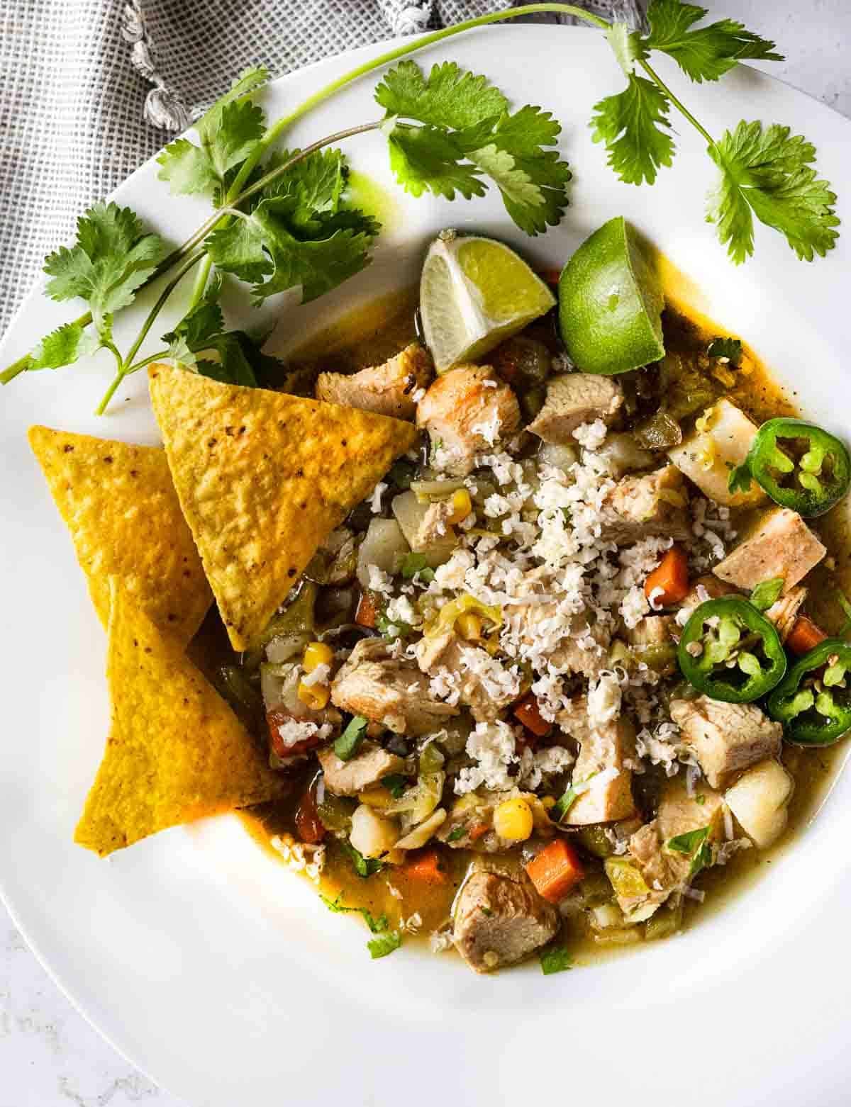 Spicy cabbage and chicken soup garnished with corn chips and cilantro.