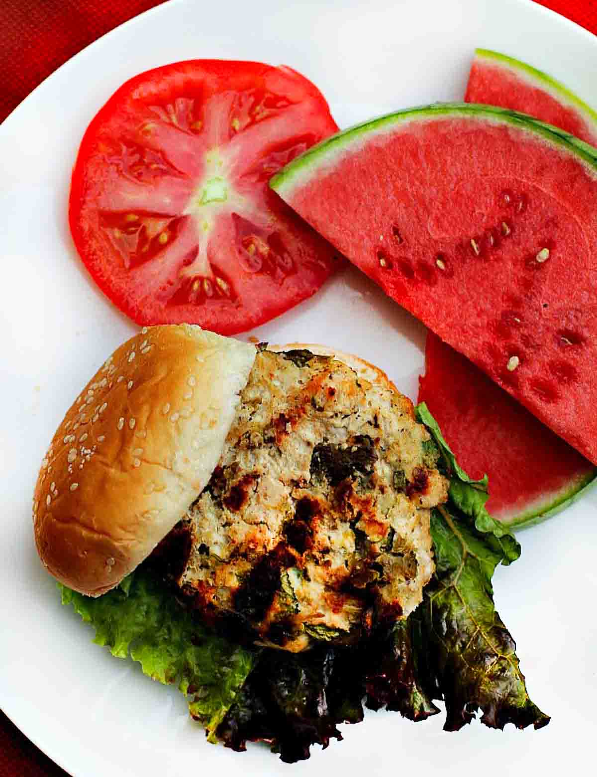 Southwest Grilled Ground Chicken Burgers served with watermelon and tomato.