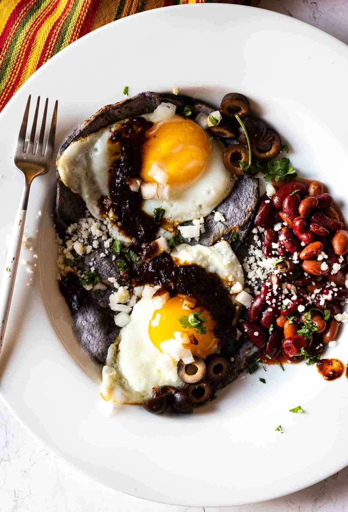 Southwestern huevos rancheros served with beans and red chile sauce.