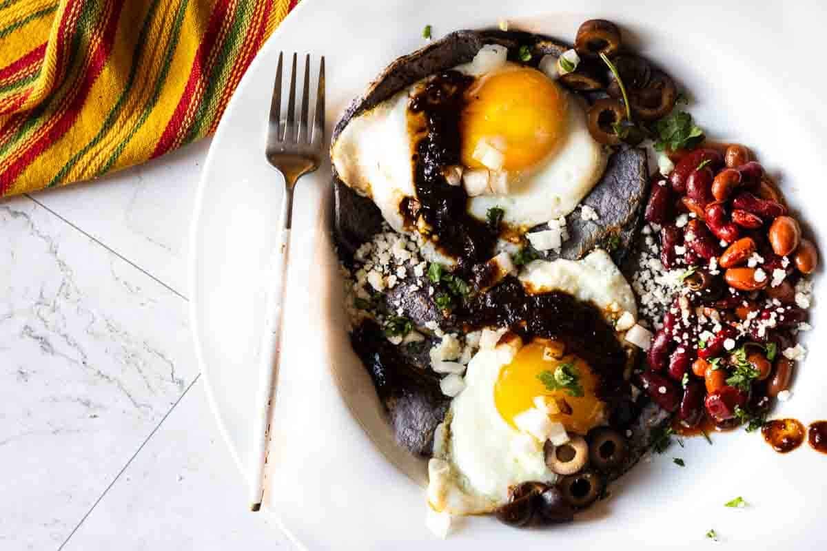 New Mexico Style Huevos Rancheros using blue corn tortillas and red chile sauce.
