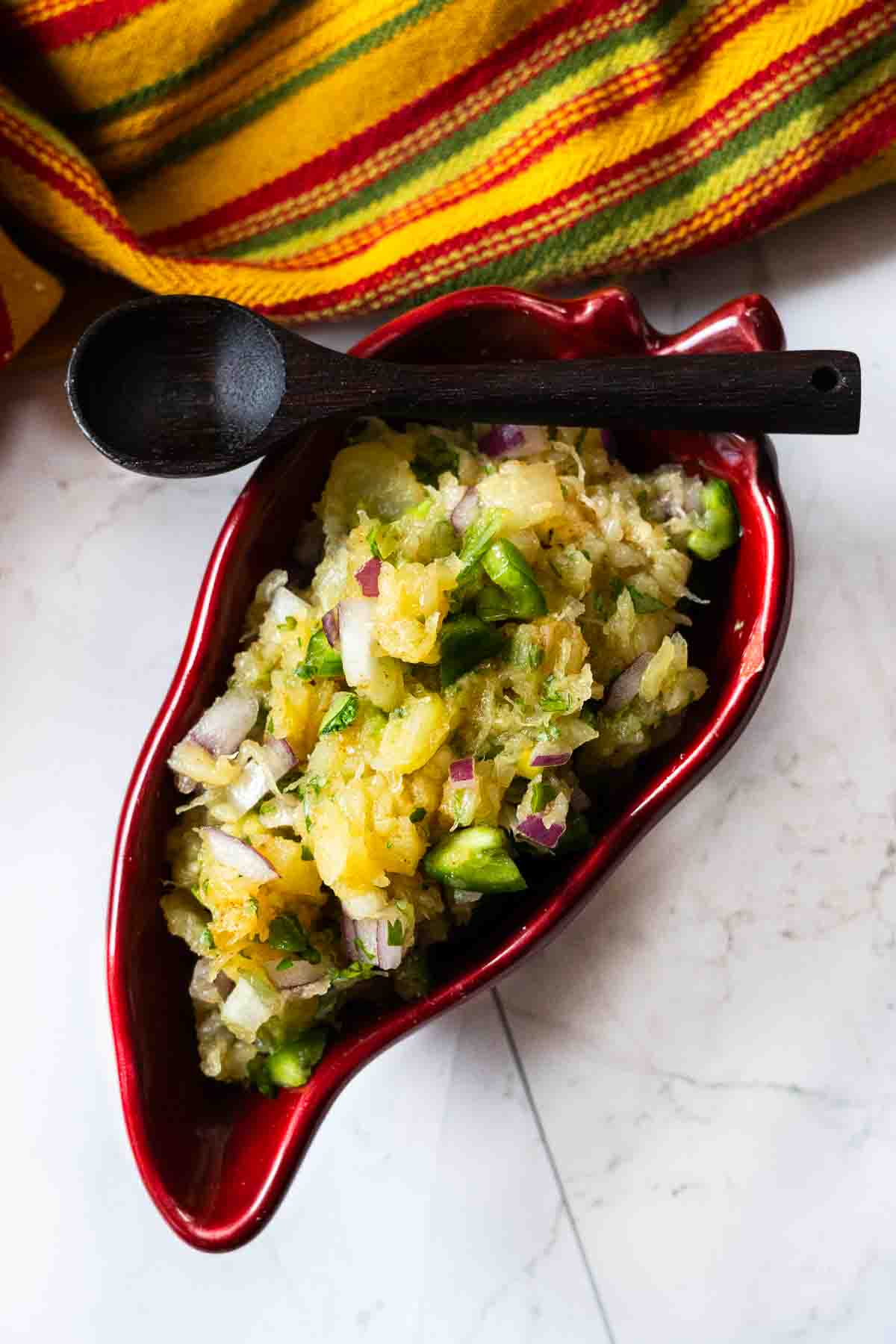 Jalapeno pineapple salsa in a red chile shaped bowl.