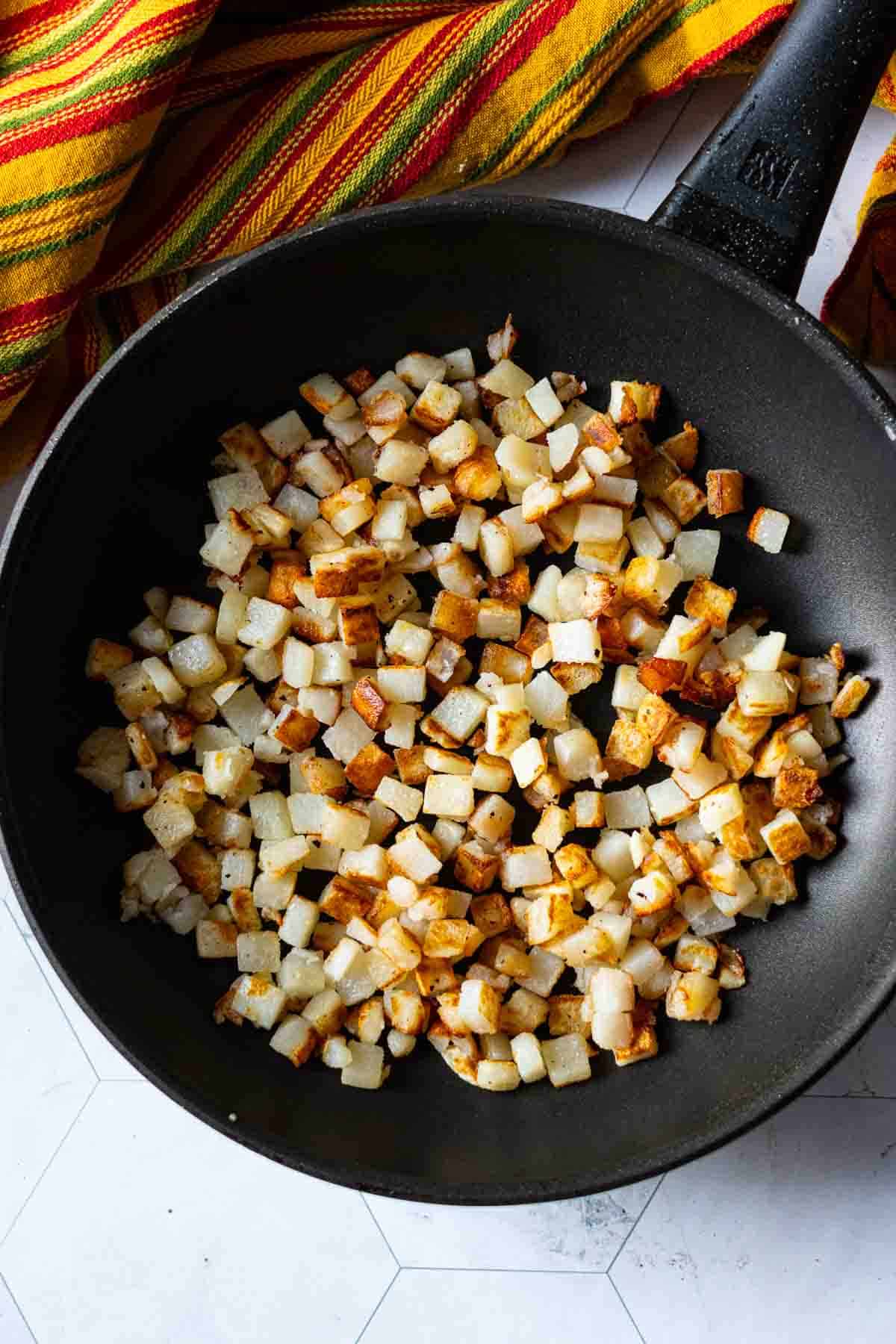 Step 1: Cooking frozen hash brown potatoes to make a chorizo breakfast burrito.