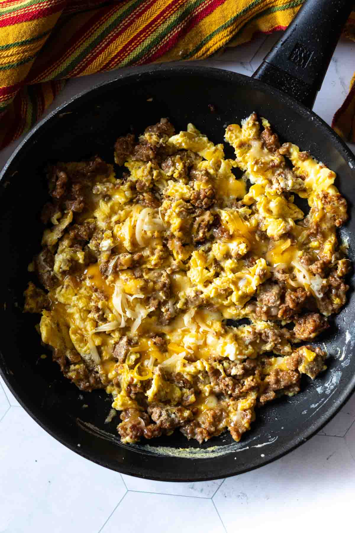 Step 4: Adding Cheese to cooked chorizo and eggs to make a chorizo breakfast burrito.
