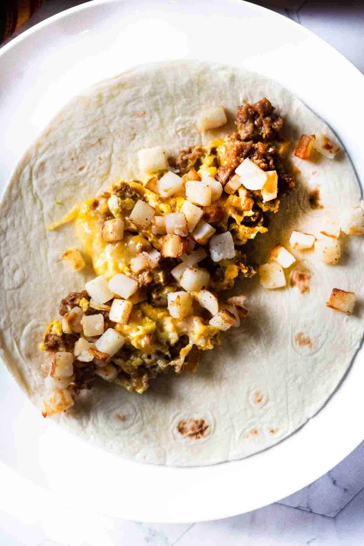 Step 5: Adding ingredients to a flour tortilla to make a chorizo breakfast burrito.
