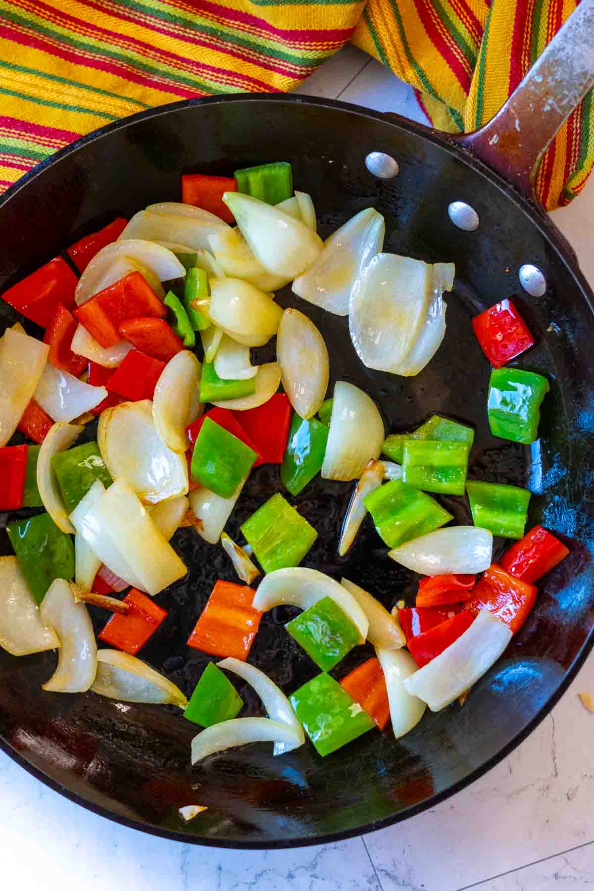 Cooking bell peppers and onions for sauteed mixed vegetables.