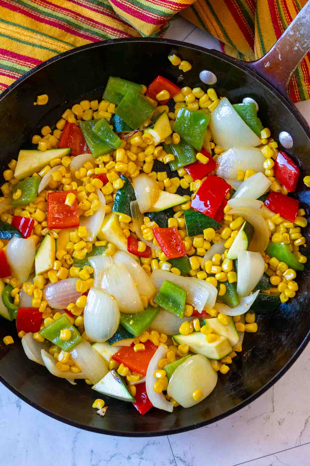 Step 2, adding corn to sauteed mixed vegetables.