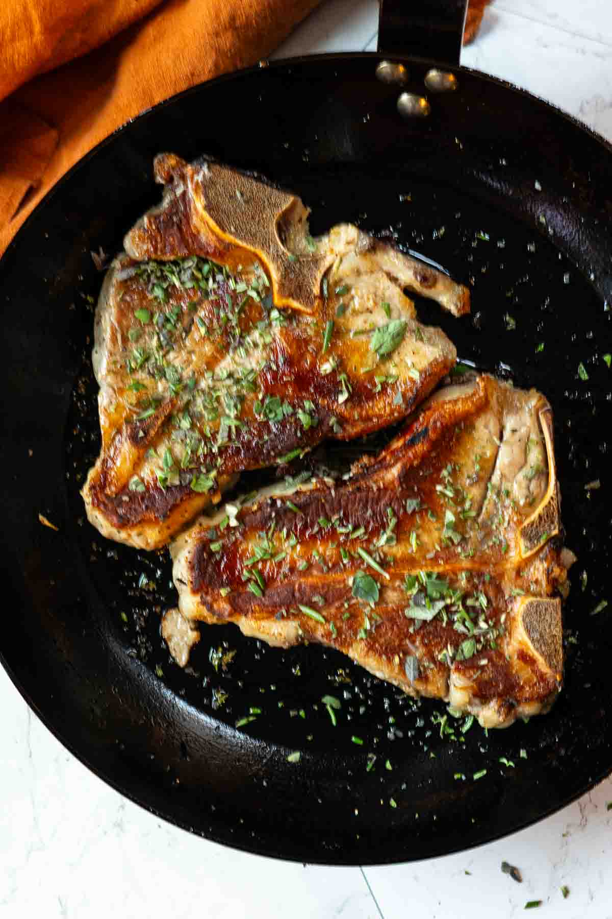 Step 2: two pan seared veal chops seasoned with fresh herbs.