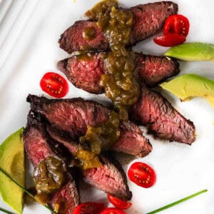 Hanging tender steak served with green chile sauce, tomatoes and avocado.