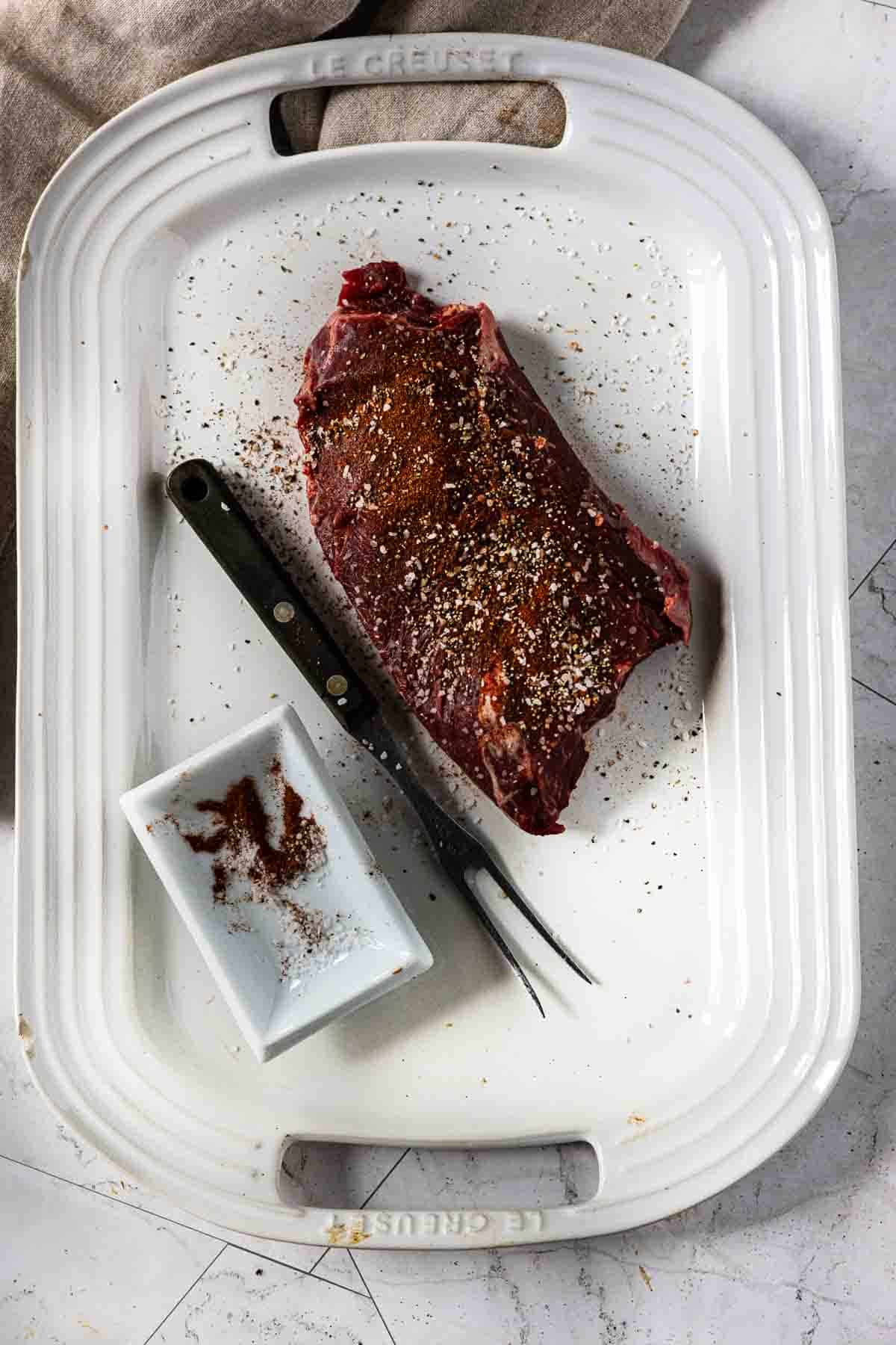 Seasoning a hanging tender steak.